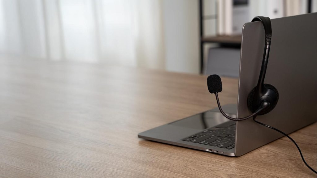 Laptop with a headset on a desk representing a business phone system dropping calls and the need for reliable communication technology.