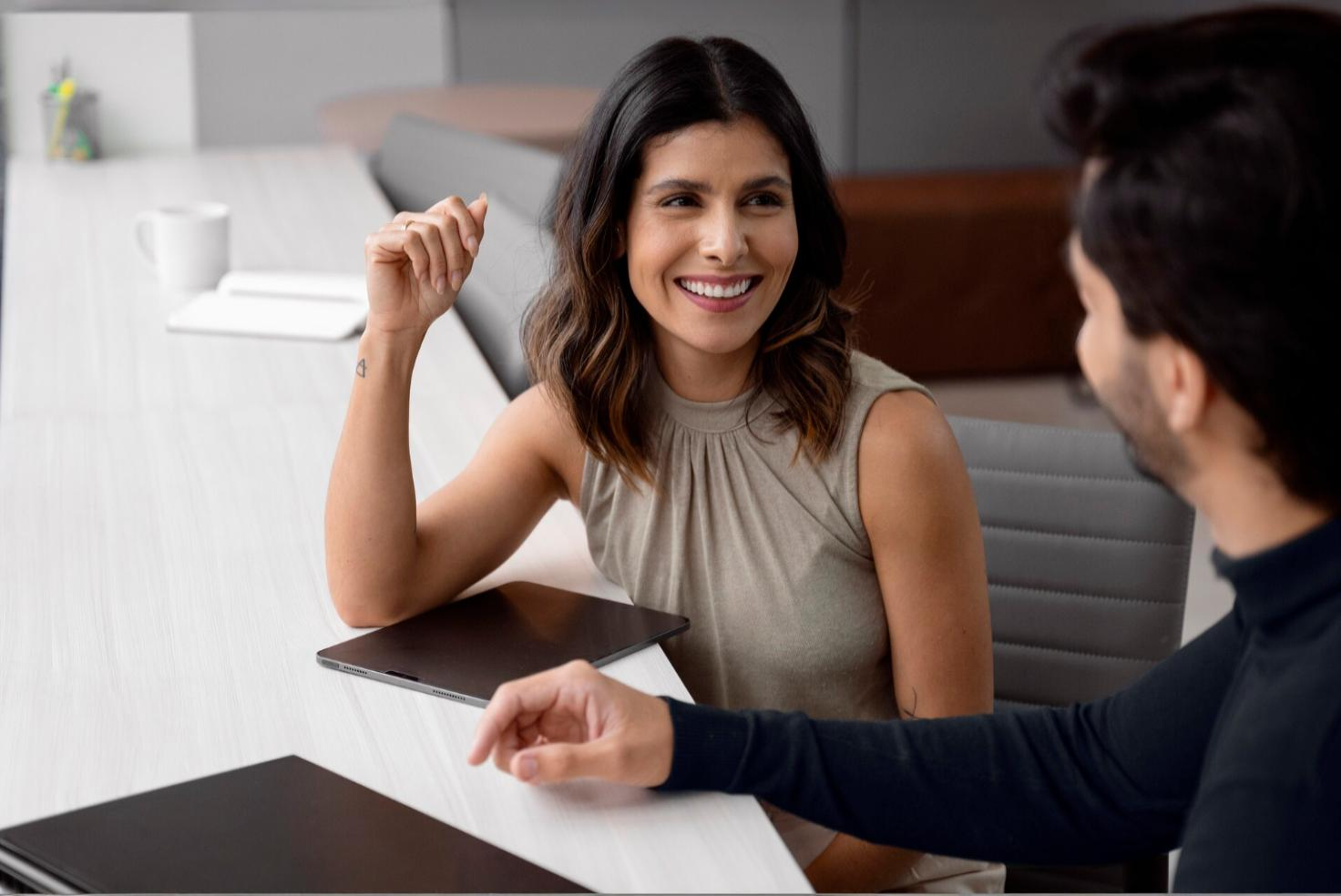 Smiling woman meeting with man at tall table in hotel. Conveying customer switching to hospitality cloud phone