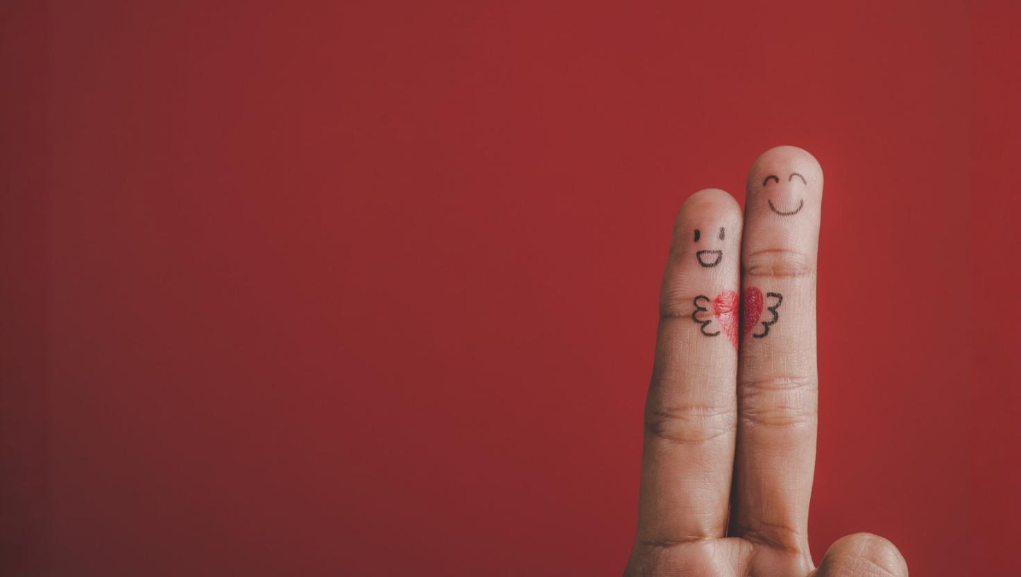 Two fingers with drawn faces on then and a heart showing 
Unified customer engagement