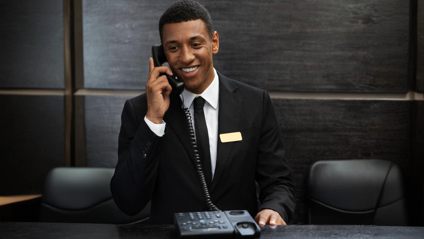 Happy man using a hotel phone system