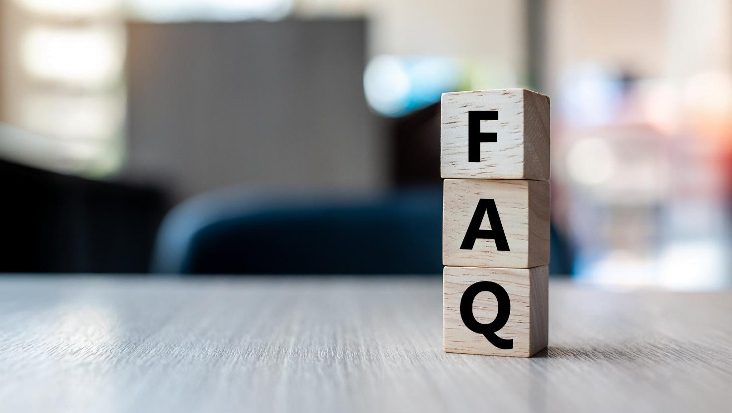 Stacked wood blocks on a table spelling FAQ–relating to common questions about hotel phone systems