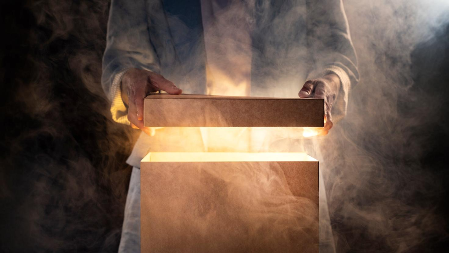 Man opening glowing box–finding right omnichannel communication platform–no need for adobe experience manager.